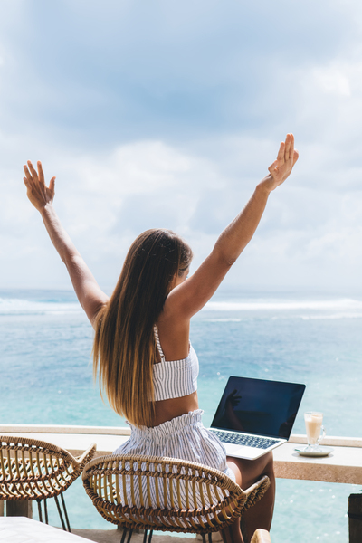 Unrecognizable woman sitting on veranda with laptop