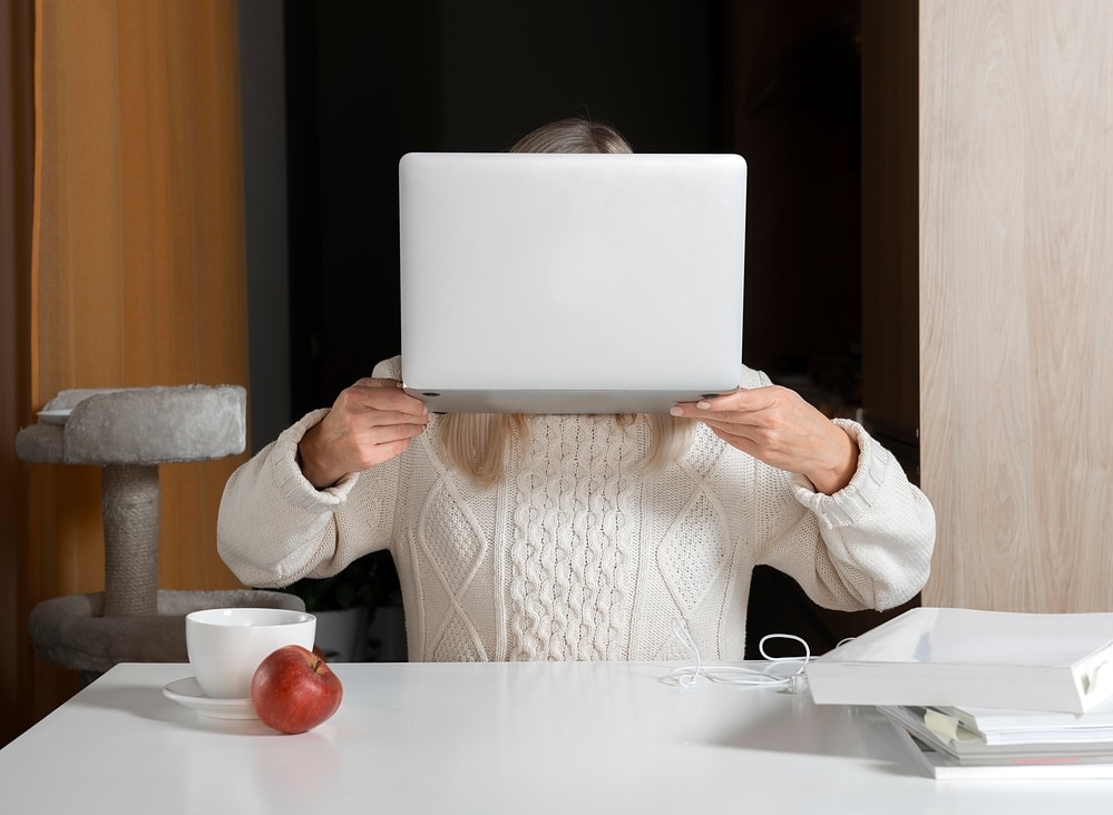 Frau versteckt sich mit Laptop
